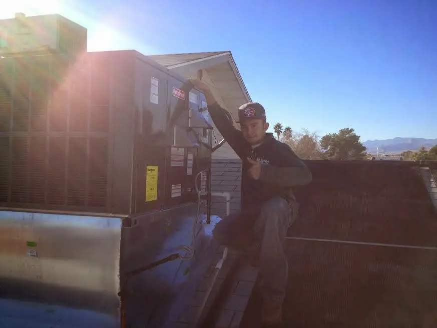 HVAC technician performing Heat Pump Repair on a rooftop unit in Carbondale